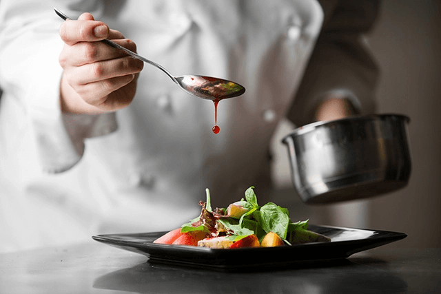 chef drizzling sauce